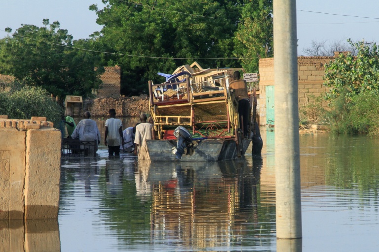 Des habitants transportent leurs effets personnels lors d'inondations dans le village de Wad Ramli au nord de Khartoum au Soudan, le 1er octobre 2025
