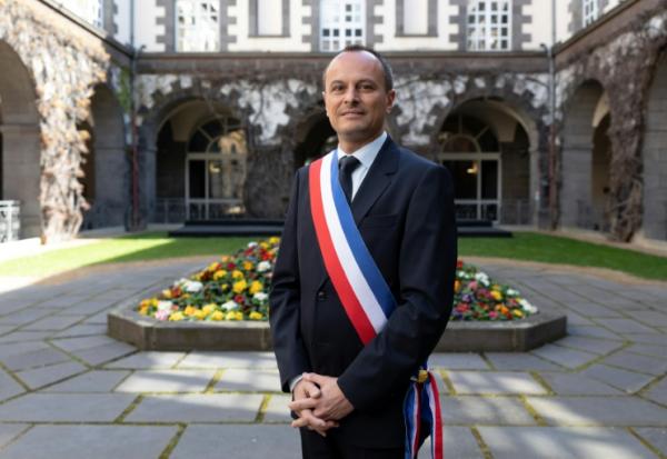 Le maire de Clermont-Ferrand, Julien Bony, ceint de son écharpe tricole, devant la mairie, le 27 mars 2026 dans le Puy-de-Dôme