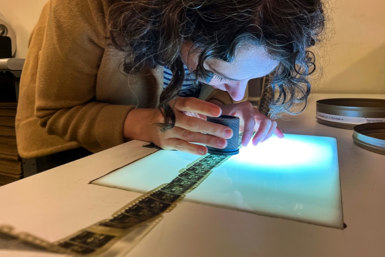 Courtney Holschuh utilise une loupe pour regarder la pellicule d'un film, au Centre national de conservation audiovisuelle de la Bibliothèque du Congrès à Culpeper, le 2 avril 2026 en Virginie