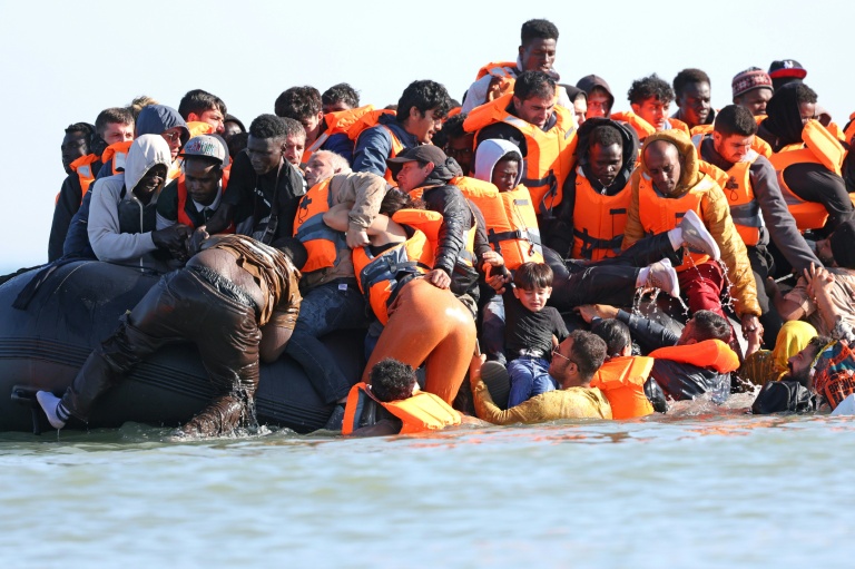 Des migrants montent à bord d'une embarcation pour tenter de traverser la Manche à Gravelines, dans le nord de la France, le 29 juillet 2026