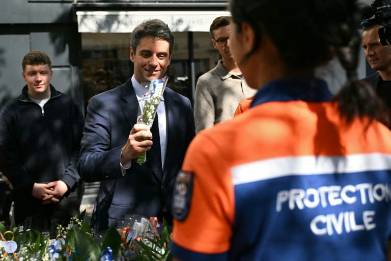 Gabriel Attal, secrétaire général de Renaissance, achète un bouquet de muguet vendu par des membres de la Protection civile à l'occasion de la Fête du Travail à Vanves, près de Paris, le 1er mai 2026