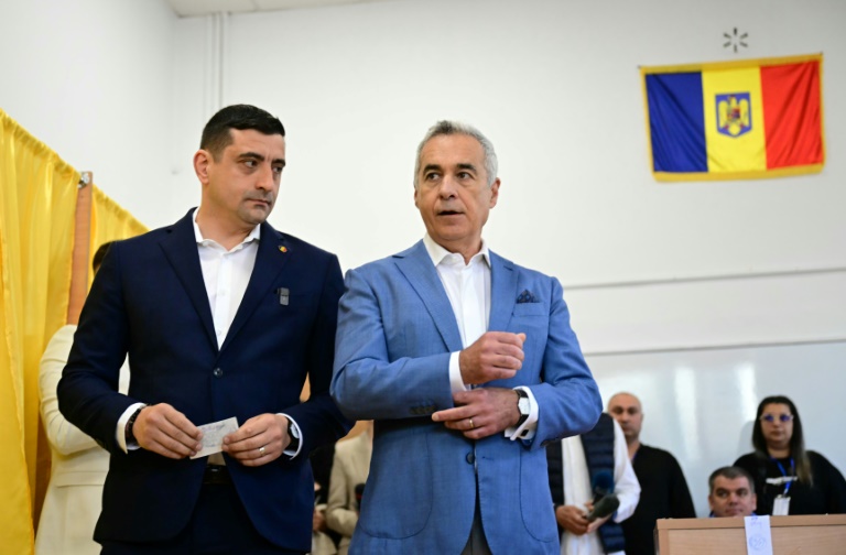 Le chef du parti nationaliste AUR et candidat à la présidentielle roumaine George Simion vote aux côtés de Calin Georgescu, exclu de la course, le 4 mai 2025 à Bucarest