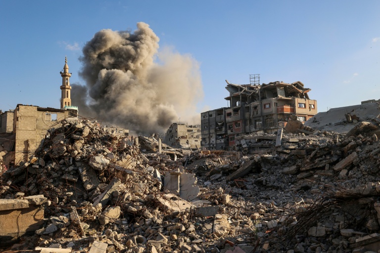 Un nuage de fumée s'élève après une frappe israélienne qui a visé un bâtiment dans le camp de réfugiés palestiniens de Bureij, dans le centre de la bande de Gaza, le 19 octobre 2025