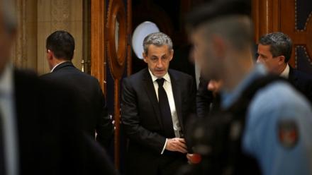 L'ancien président Nicolas Sarkozy (c) quitte le palais de justice de Paris pendant une pause dans le cadre de son procès en appel sur le financement libyen de sa campagne présidentielle de 2007, le 16 mars 2026