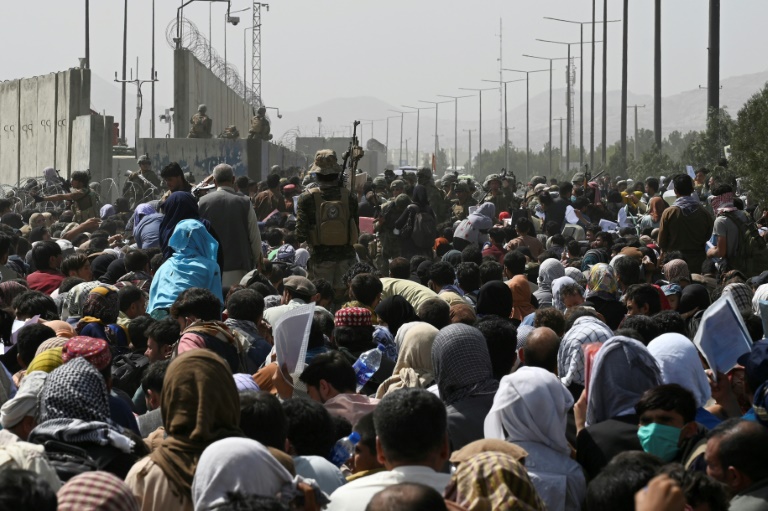 Des milliers d'Afghans sur une route proche du secteur militaire de l'aéroport de Kaboul espèrent pouvoir fuir le pays après la prise de la capitale par les talibans, le 16 août 2021 