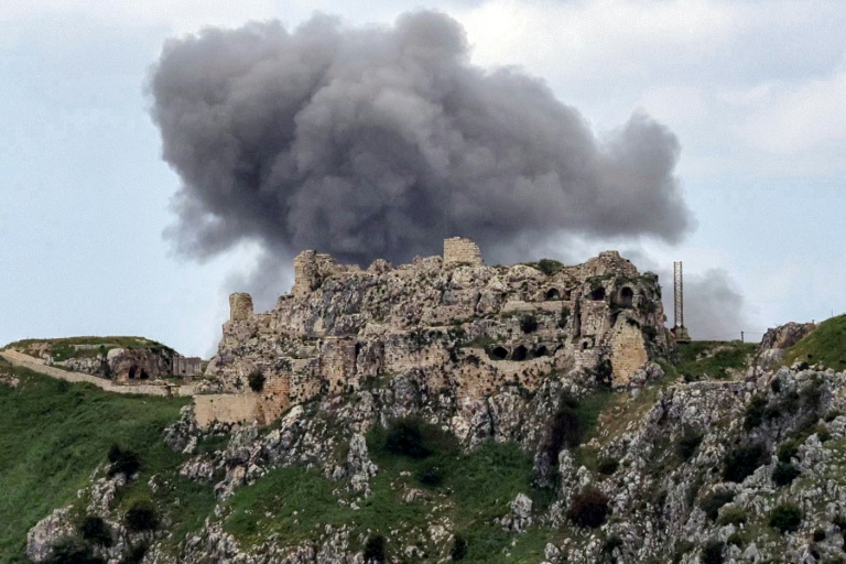 De la fumée s'élève du village libanais de Yohmor, derrière le château de Beaufort, une forteresse datant des croisades, le 6 mai 2026