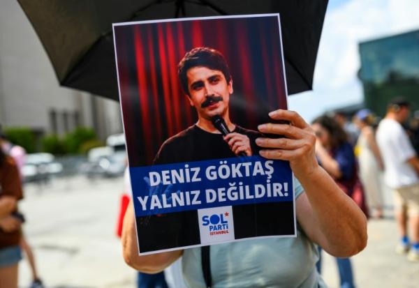 Une personne tient une pancarte de soutien à l'humoriste turc Deniz Goktas, sur laquelle on peut lire "Deniz Goktas n'est pas seul", lors d'une manifestation devant le palais de justice de Çağlayan, à Istanbul, le 3 juillet 2026