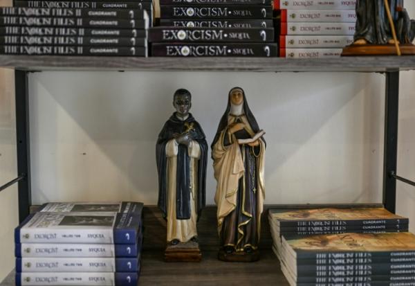 Des statuettes de saints sur une étagère de livres dans le Centre Saint-Michel pour la libération spirituelle et l'exorcisme, le 18 juillet 2026 à Manille 