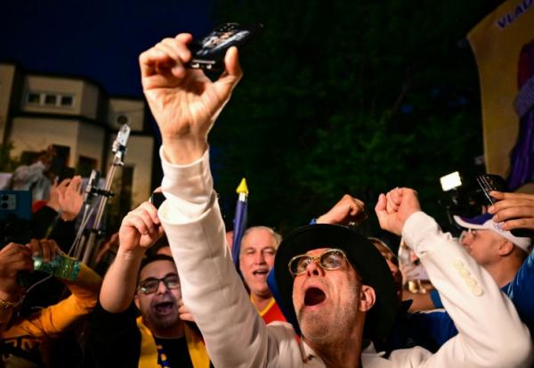 Des partisans du chef du parti AUR George Simion saluent sa victoire au premier tour de la présidentielle, le 4 mai 2025 à Bucarest