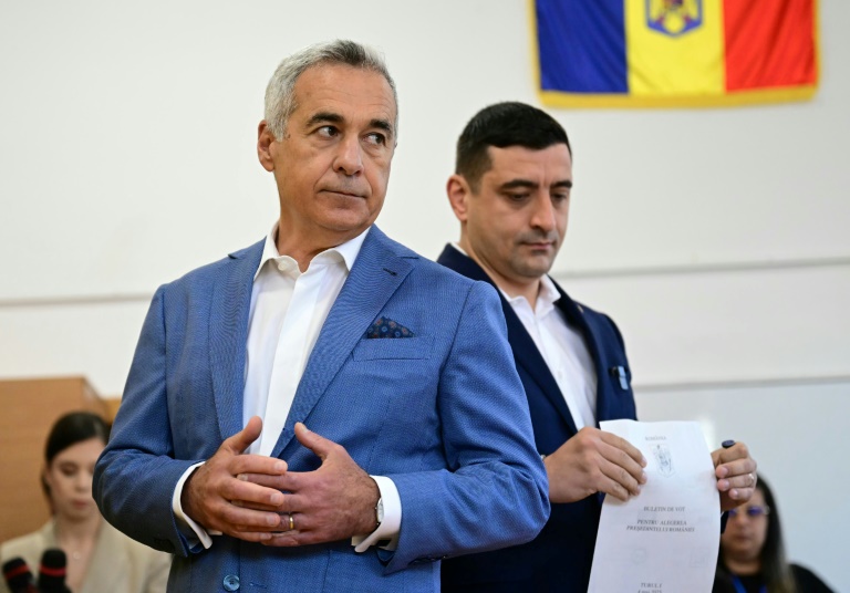 Le chef du parti nationaliste AUR et candidat à la présidentielle roumaine George Simion vote aux côtés de Calin Georgescu, exclu de la course, le 4 mai 2025 à Bucarest