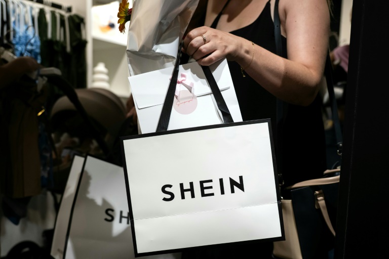 Une cliente à la sortie d'un magasin éphémère de la marque chinoise de fast fashion Shein à Dijon, le 26 juin 2025