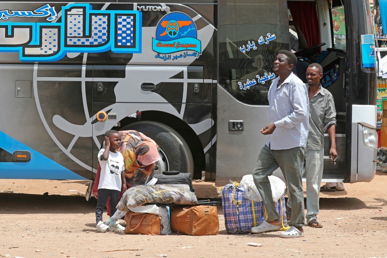 Des Soudanais déplacés arrivent à un arrêt de bus à Khartoum le 22 septembre 2026, alors que des familles retournent dans la capitale