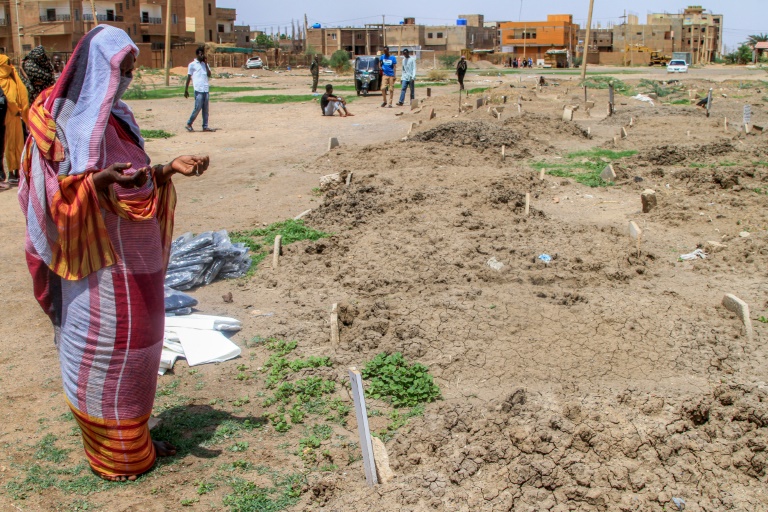 Une femme récite une prière devant des tombes dans le quartier d'Al-Azhari dans la banlieue de Khartoum, le 2 août 2025