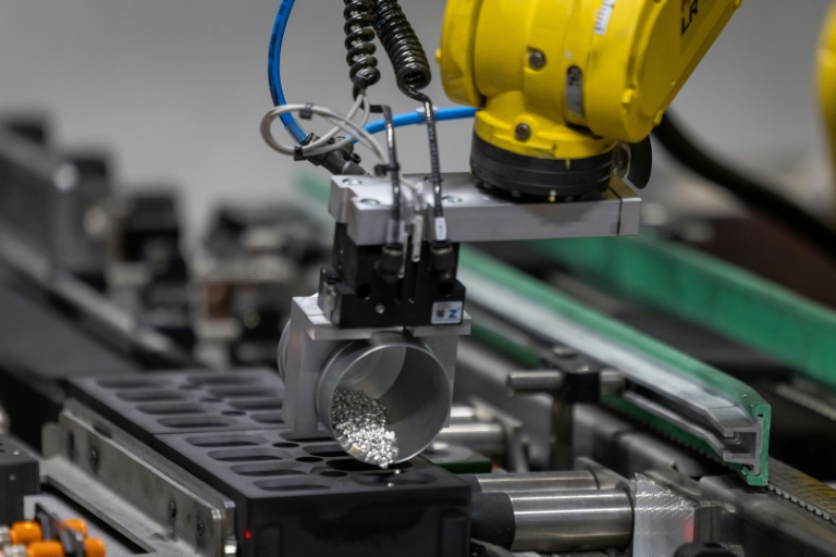 Un bras robotisé dose des granulés d’argent pour fusionner de petits lingots d'argent dans la fonderie de Głogow, en Pologne, le 24 mars 2026
