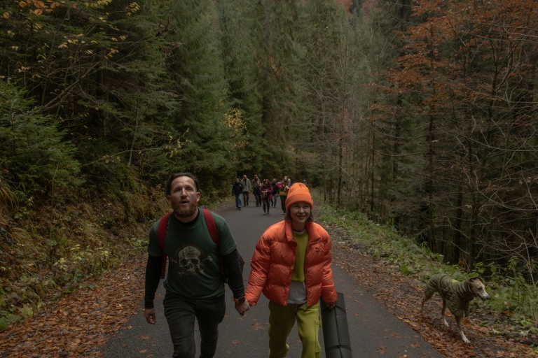 Anastassia Podobaïlo (d) et son collègue et époux Mykola Iassinenko participent à une randonnée lors d'une retraite en montagne destinée à soutenir le rétablissement psychologique et le bien-être mental des médecins militaires ukrainiens dans la région de Transcarpatie, dans l'ouest de l'Ukraine, le 27 octobre 2025