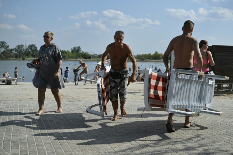 Des personnes se détendent sur les rives du lac Sloviansk, dans la région de Donetsk, le 6 août 2025
