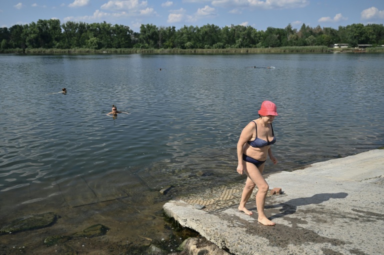 Raissa, 67 ans, sort de l'eau à Sloviansk, le 6 août 2025, dans la région de Donetsk
