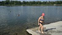 Raissa, 67 ans, sort de l'eau à Sloviansk, le 6 août 2025, dans la région de Donetsk