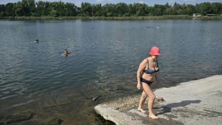Raissa, 67 ans, sort de l'eau à Sloviansk, le 6 août 2025, dans la région de Donetsk