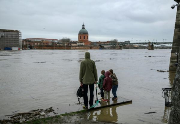 Des personnes observent la Garonne après de fortes pluies, à Toulouse, le 11 février 2026