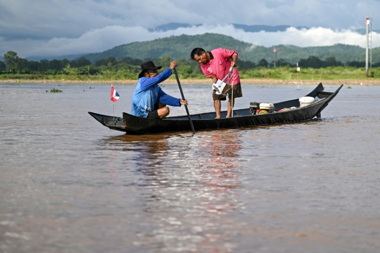 Le pêcheur Chaweng Yothaud (d) prélève des échantillons pour tester un empoisonnement à l'arsenic le long de la rivière Kok dans la région du Triangle d'or, dans la province de Chiang Rai, dans le nord de la Thaïlande, le 25 mai 2025