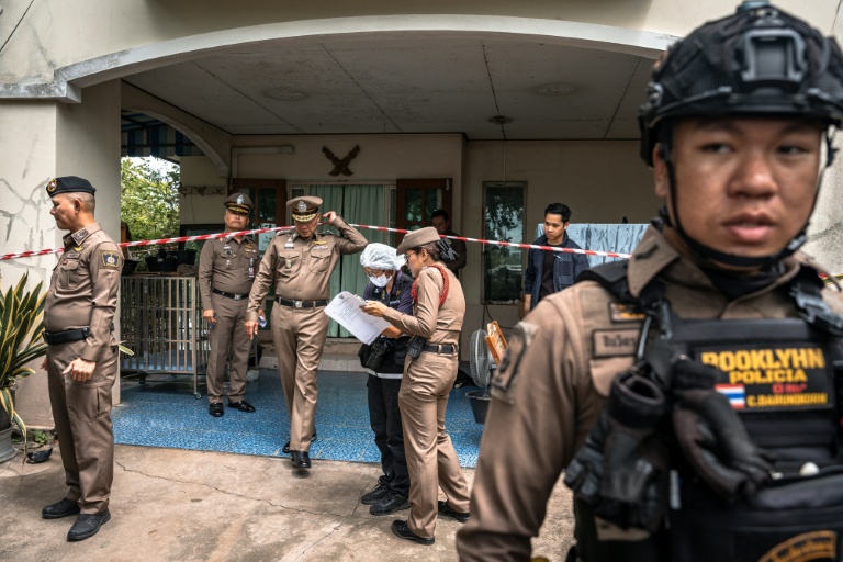 Des policiers devant la maison où un adolescent a tué ses grands-parents avant de commettre une fusillade dans une école au nord de Bangkok, la capitale de la Thaïlande (7 août 2026)