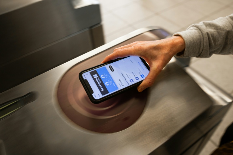 Utilisation d'un pass Navigo sur un iphone dans une station de métro à Paris, le 24 mai 2024.