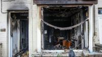 L'entrée et la fenêtre d'une maison brûlées après une deuxième nuit d'émeutes visant des immigrés à Ballymena, le 11 juin 2025 en Irlande du Nord