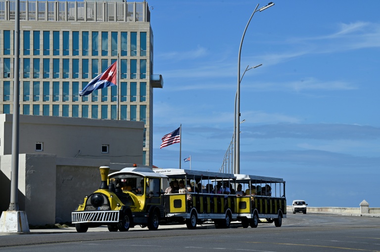 Un train touristique passe devant l'ambassade des États-Unis à La Havane, le 11 janvier 2026 à Cuba