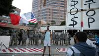 Un homme brandit un drapeau aux couleurs des Etats-Unis et du Mexique devant des membres de la Garde nationale, à Los Angeles (Californie), le 12 juin 2025