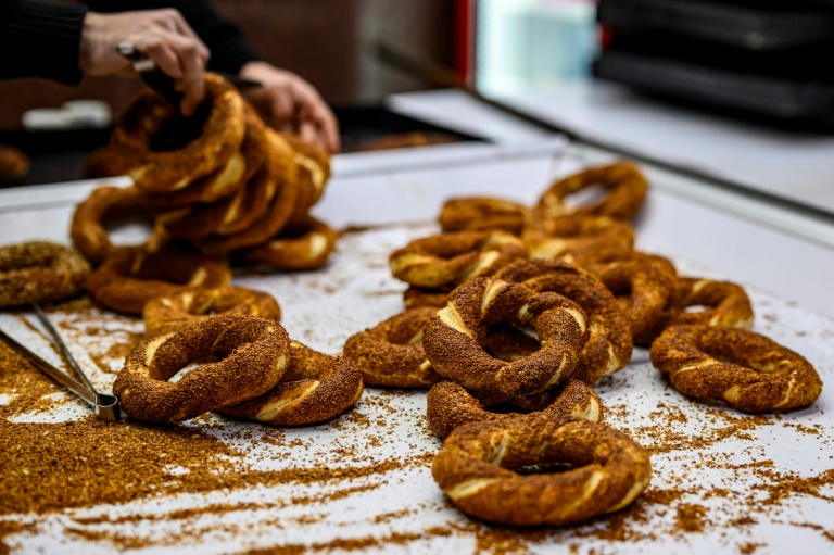 Un vendeur de rue agrémente de sésame ses simits, des petits pains turcs en forme d'anneau, le 27 décembre 2025 à Istanbul