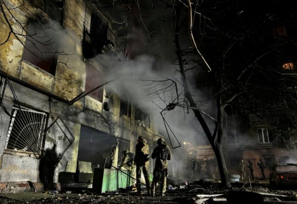 Des membres des forces de l'ordre sont mobilisés dans la cour d'un immeuble résidentiel endommagé à la suite d'une attaque aérienne russe à Zaporijjia le 25 novembre 2025 dans le sud de l'Ukraine