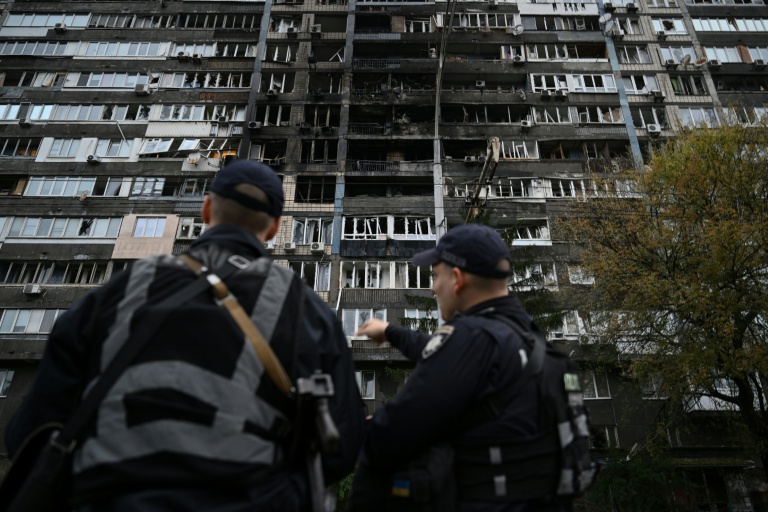 Des policiers ukrainiens devant un immeuble résidentiel endommagé par des frappes massives de drones et de missiles russesà Kiev, le 10 octobre 2025