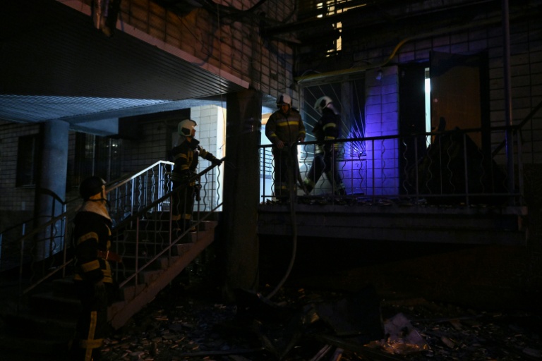 Des pompiers ukrainiens dans un immeuble résidentiel endommagé par des frappes massives de drones et de missiles russesà Kiev, le 10 octobre 2025