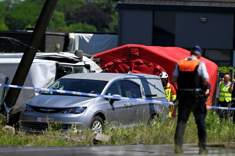 Un corbillard stationné sur le site d'un accident entre un train et un bus scolaire, au passage à niveau de Vierhuizen à Buggenhout, au nord de Bruxelles, le 26 mai 2026 en Belgique