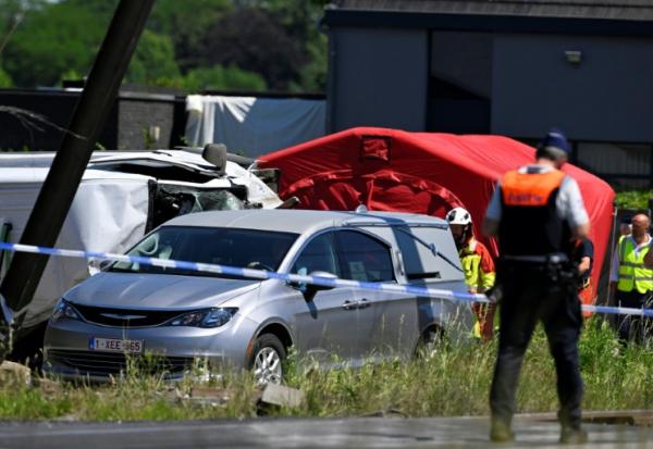 Un corbillard stationné sur le site d'un accident entre un train et un bus scolaire, au passage à niveau de Vierhuizen à Buggenhout, au nord de Bruxelles, le 26 mai 2026 en Belgique
