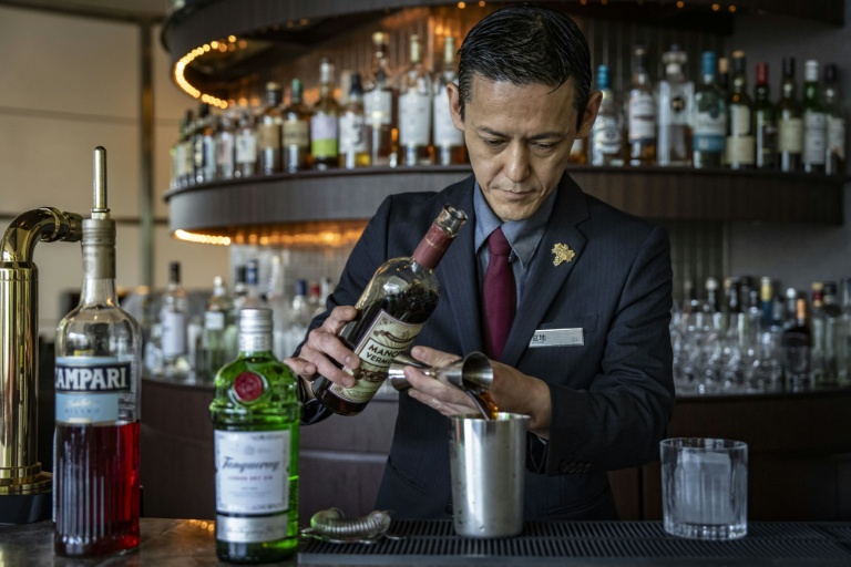 Le barman Shingo Miyachi prépre un cocktail negroni au bar de l'hôtel Hilton de Narita, au Japon, le 19 juin 2026