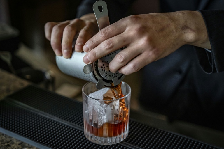 Le barman Shingo Miyachi prépre un cocktail negroni avec un glaçon de l'usine kuramoto Ice au bar de l'hôtel Hilton de Narita, au Japon, le 19 juin 2026