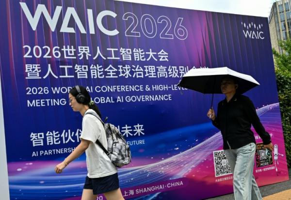 Des passants devant l'affiche de la Conférence mondiale sur l'intelligence artificielle (WAIC), le 16 juillet 2026 à Shanghai, en Chine