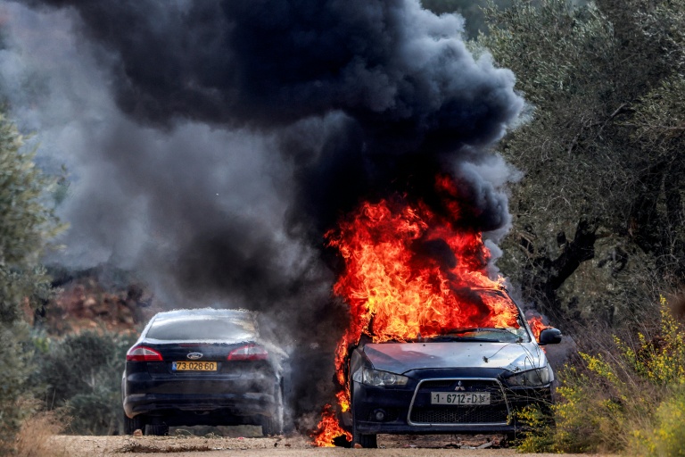 La voiture du photographe palestinien de l'AFP Jaafar Ashtiyeh en feu après une attaque de colons israéliens contre le village palestinien de Beita, au sud de Naplouse, le 10 octobre 2025 en Cisjordanie occupée