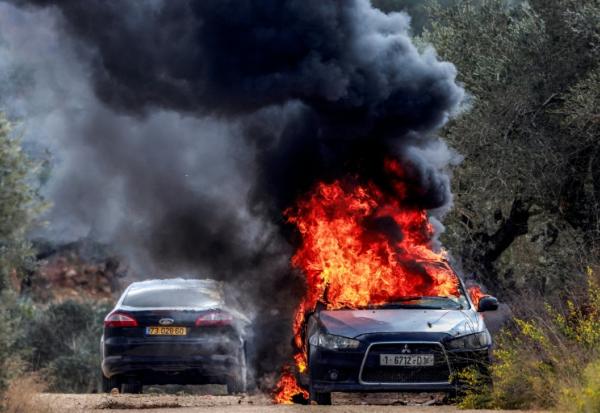 La voiture du photographe palestinien de l'AFP Jaafar Ashtiyeh en feu après une attaque de colons israéliens contre le village palestinien de Beita, au sud de Naplouse, le 10 octobre 2025 en Cisjordanie occupée