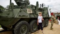Des visiteurs prennent la pause près d'un véhicule blindé, en marge de la parade militaire qui doit parcourir les rues de Washington, le 14 juin 2025