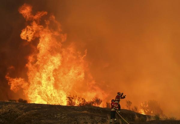 Des pompiers luttent contre un incendie à Casal do Monte, au Portugal, le 13 août 2025