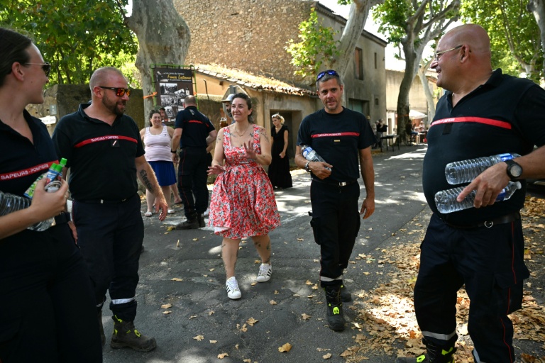 Une femme remercie les pompiers pour leur lutte contre les incendies à Tournissan, dans le sud de la France, le 10 août 2025