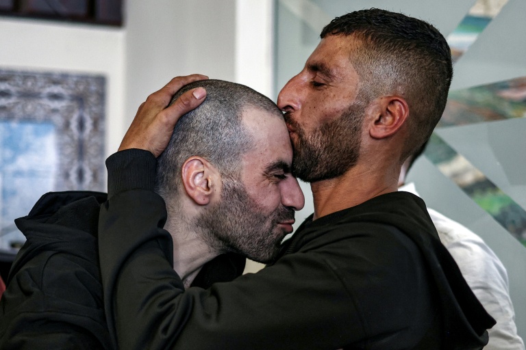 Un prisonnier palestinien libéré est accueilli par son frère à son arrivée à Ramallah en Cisjordanie, le 13 octobre 2025