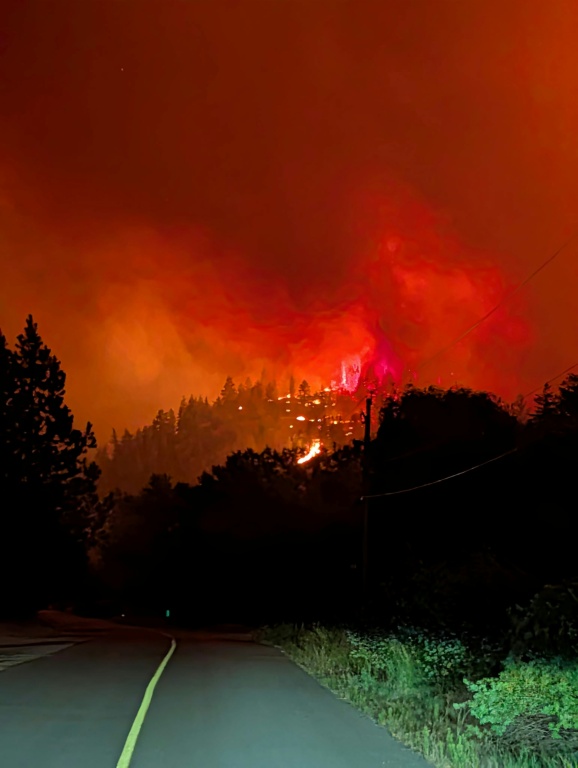 Photo prise le 7 août 2026 et diffusée le lendemain par le Service canadien de la faune de Colombie-Britannique montrant des pompiers luttant contre un incendie de forêt près de Summerland, dans l’ouest du Canada