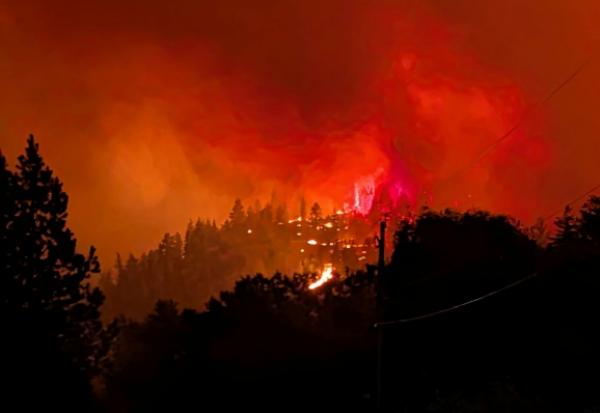 Photo prise le 7 août 2026 et diffusée le lendemain par le Service canadien de la faune de Colombie-Britannique montrant des pompiers luttant contre un incendie de forêt près de Summerland, dans l’ouest du Canada