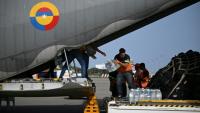 Déchargement de packs de bouteilles d'eau d'un avion de l'armée de l'air colombienne à l'aéroport international Simón Bolívar de La Guaira, le 26 juin 2026 au Venezuela après deux séismes dévastateurs 