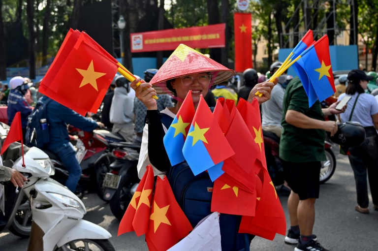 Une vendeuse de drapeaux vietnamiens et de l'armée Viet Cong, le 29 avril 2025 à Ho Chi Minh Ville