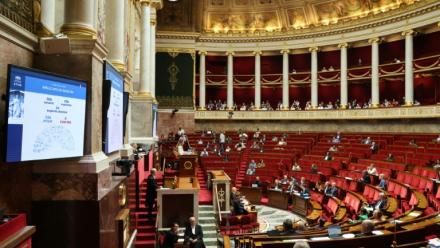 Un écran affiche l'adoption par les députés du premier article de la loi sur la protection de l'enfance et la lutte contre la violence dans les écoles à l'Assemblée nationale, le 1er juin 2026 à Paris
